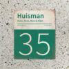 Naambord-Huisman-22-vlakken-nummer-onder-Koenmeloen--donkergroen-wit-muur